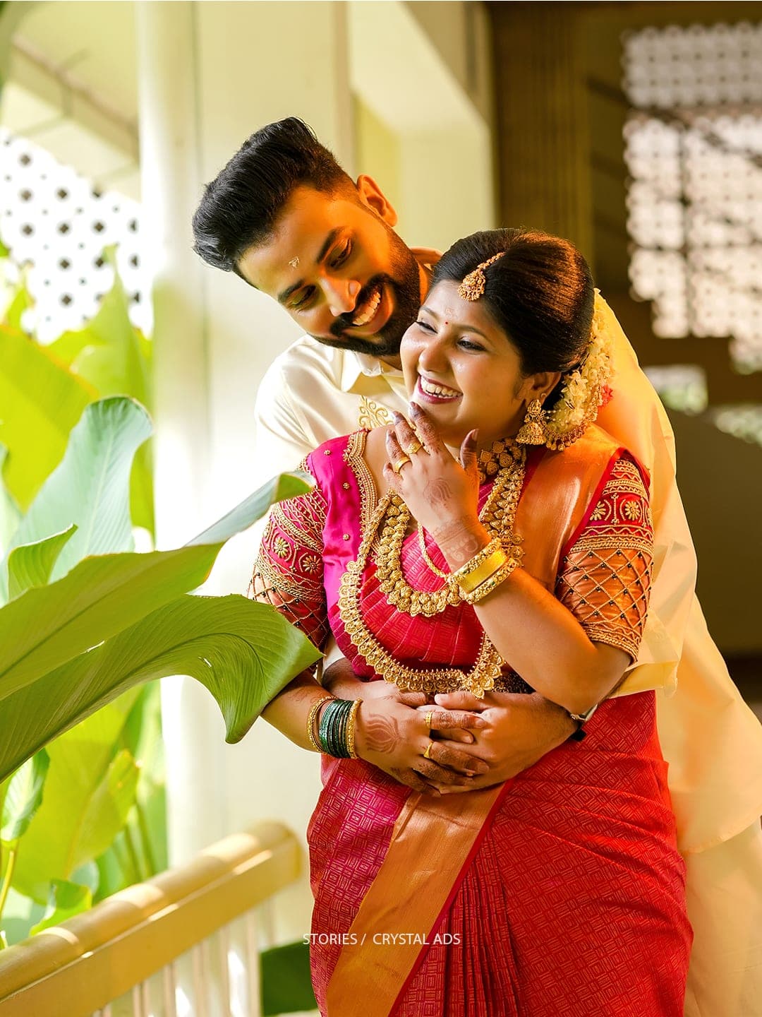 Bride and groom laughing together as he holds her from behind
